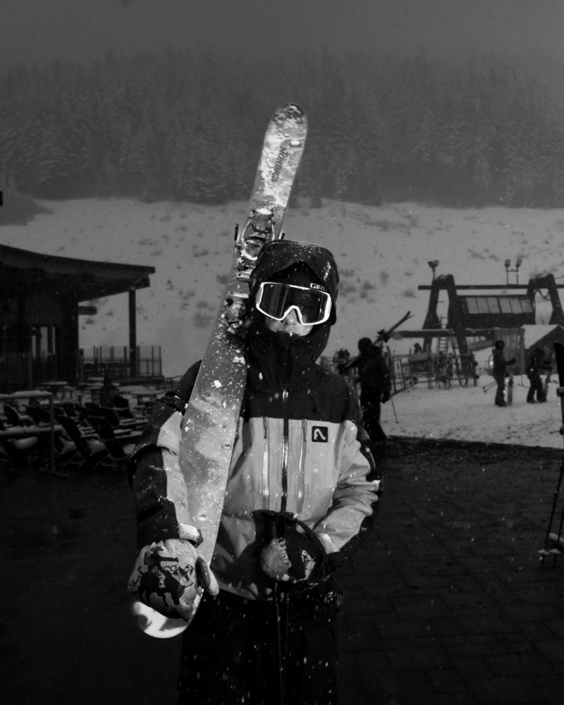 Cooper in black and white ski gear holding a ski