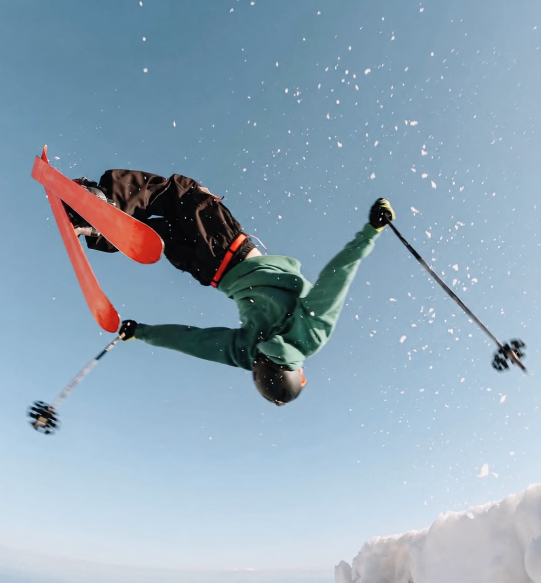 Sam flipping on skis in green